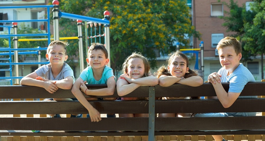 Children on brown bench near playground