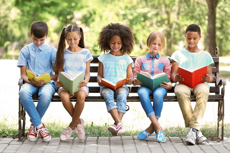Children reading books on bench